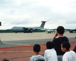 C5-Taxiing The C-5 taxies out. Notice the relative size of the F-18 in the foreground.